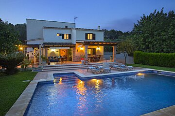 A house with a large swimming pool in front of it