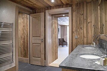 A bathroom with two sinks and wooden walls