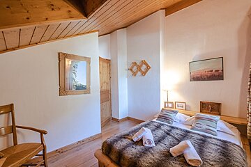 A bedroom with a bed and a picture on the wall