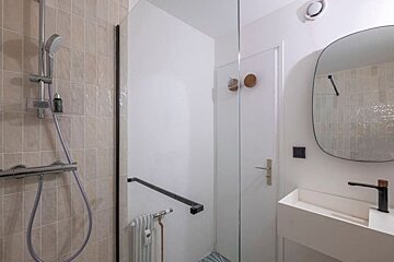 A bathroom with a shower and a sink and a mirror