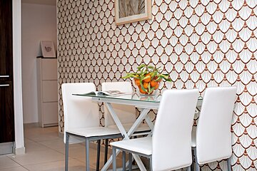 A dining room table with a bowl of fruit on it