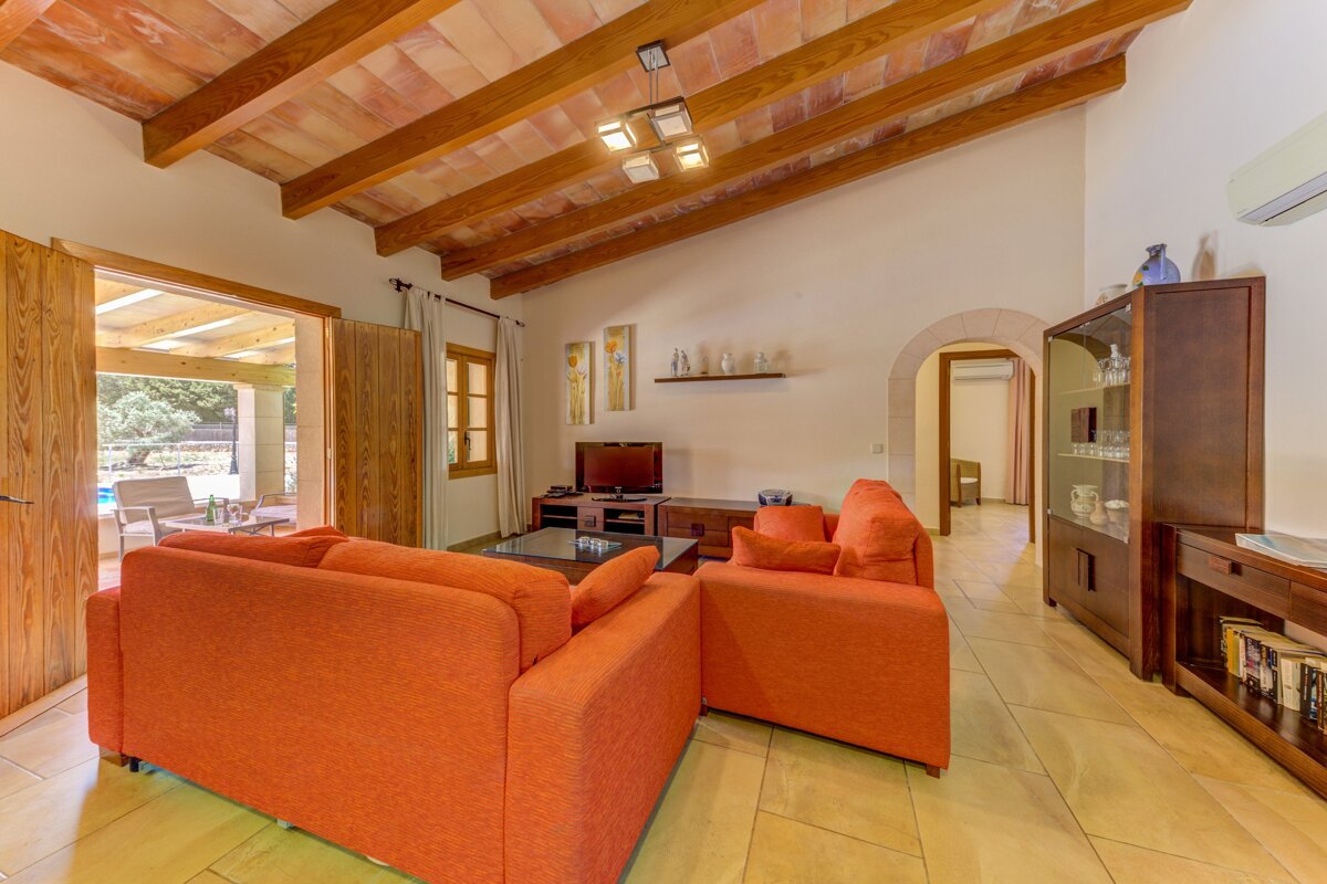 A living room with two orange couches and a television