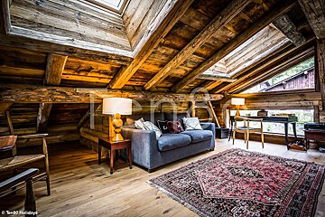 A living room with a couch and a rug and a skylight