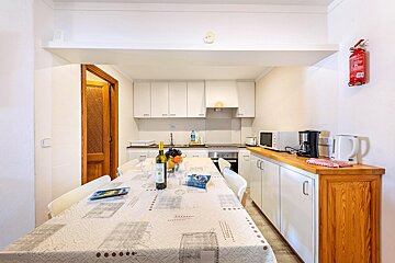 A kitchen with white cabinets and a fire extinguisher on the wall