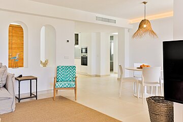 A living room with a blue chair and white chairs