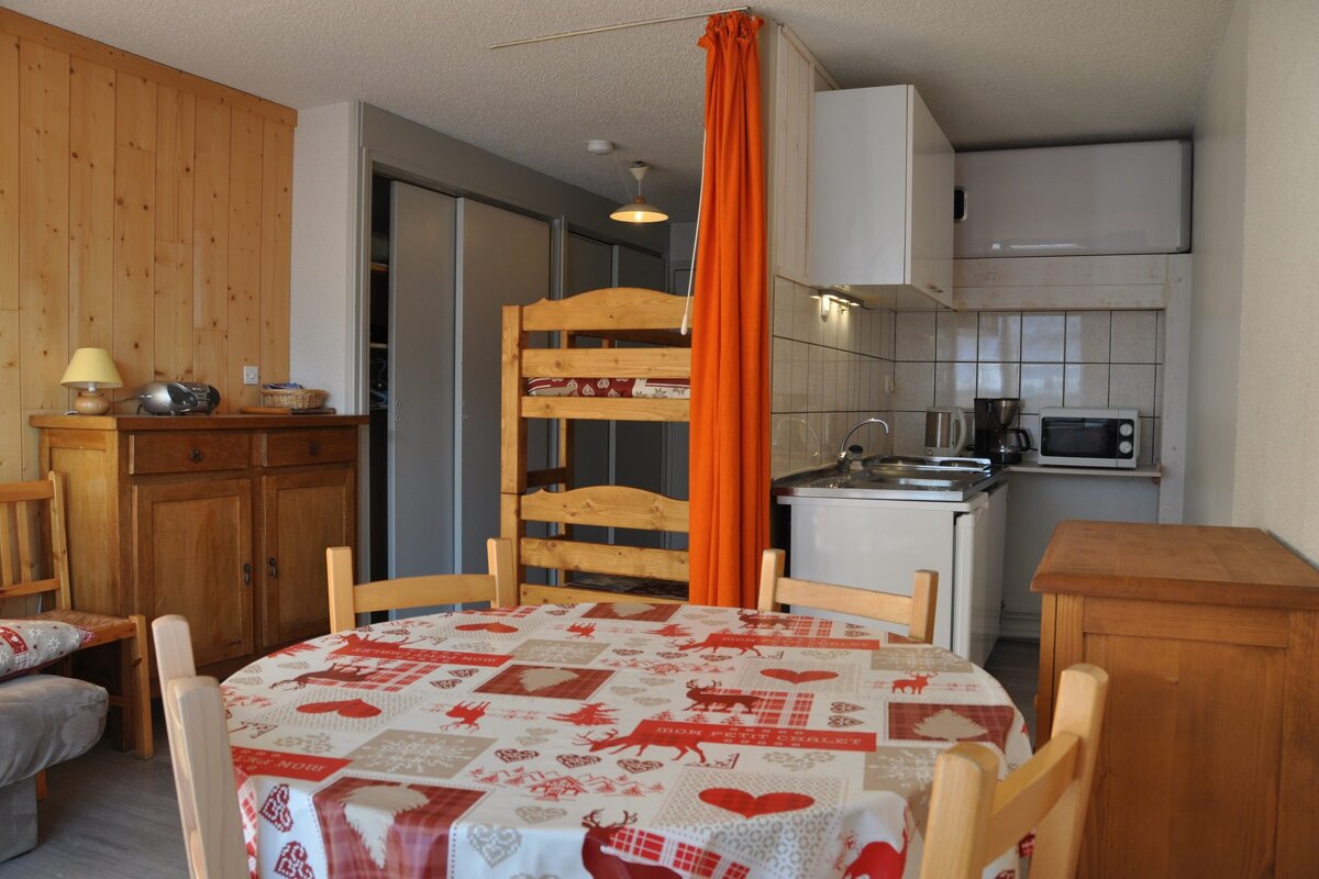 A kitchen with a table and chairs and a bunk bed