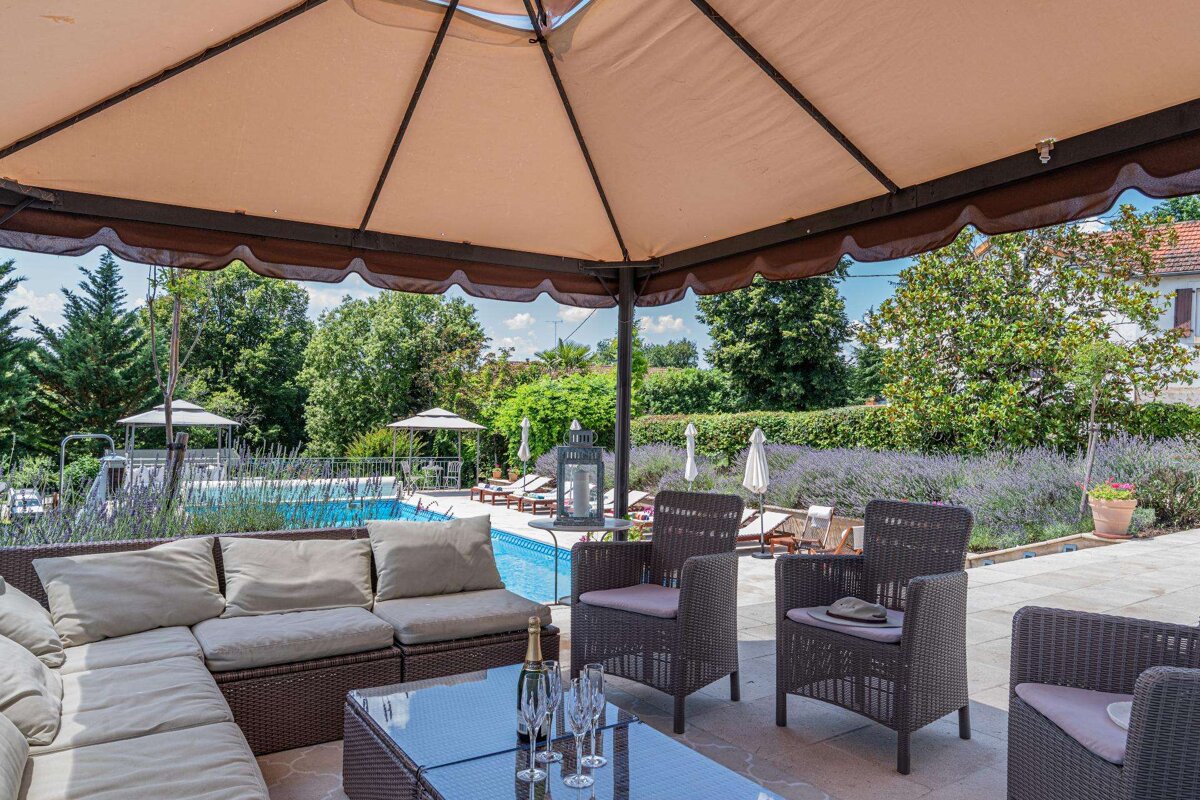 A table with a bottle of champagne on it sits under a gazebo