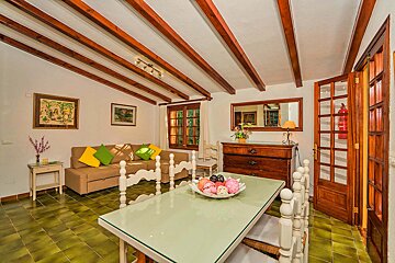 A living room with a couch and a table with a bowl of fruit on it
