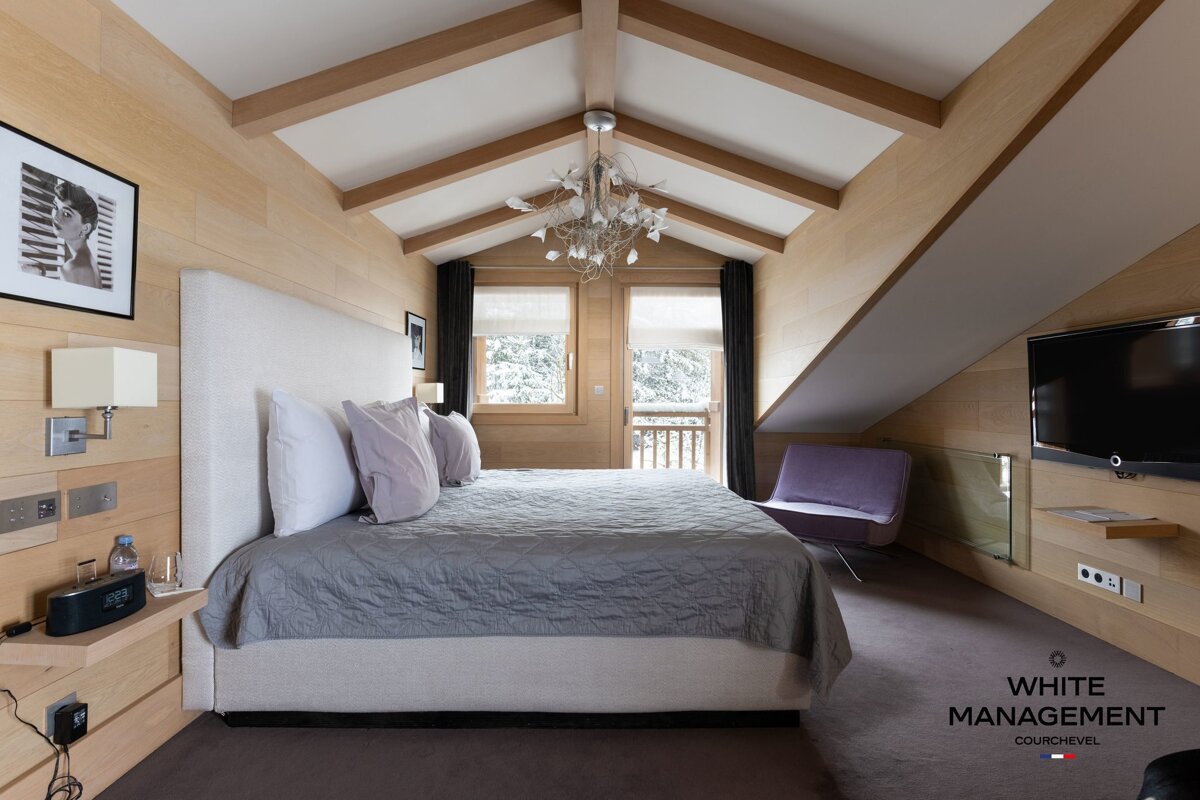 A large indoor swimming pool with purple pillows and lights on the ceiling