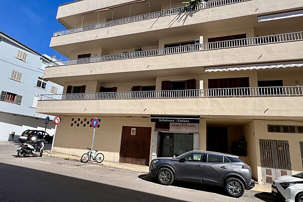 A cream multi-story building with balconies and a 