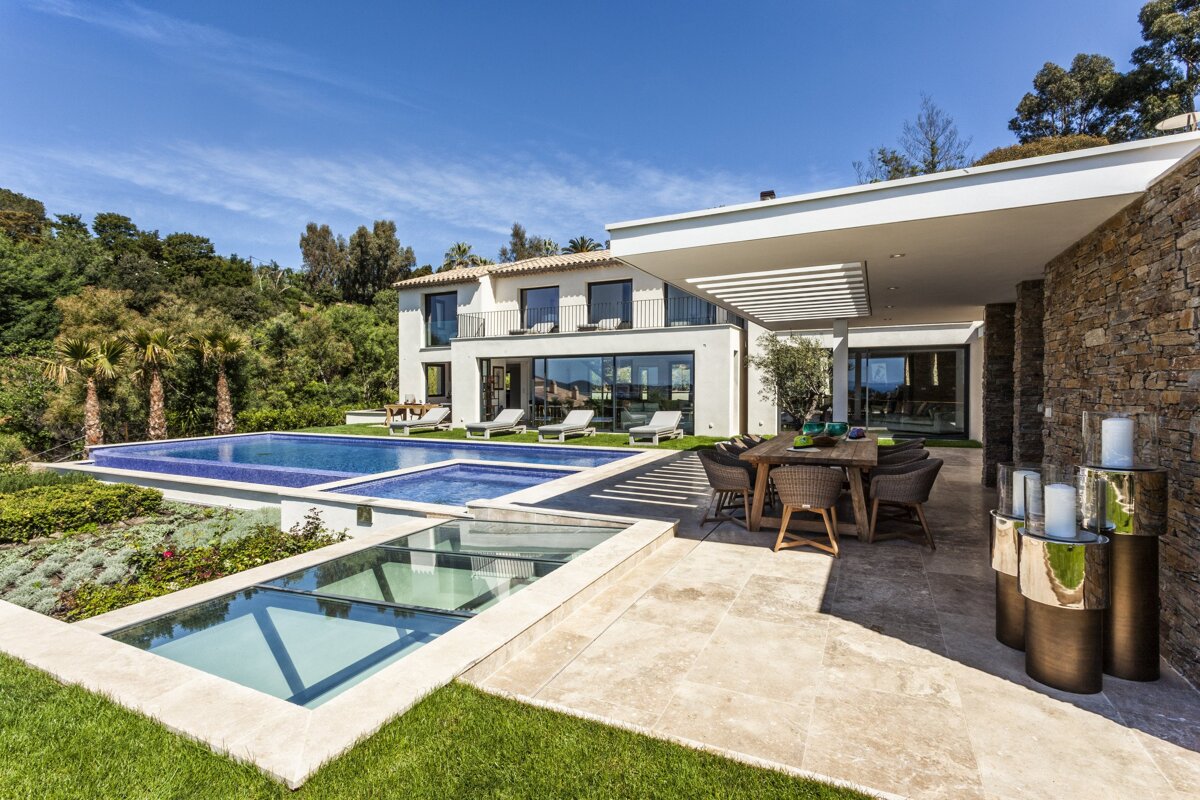 A large house with a swimming pool and a dining table