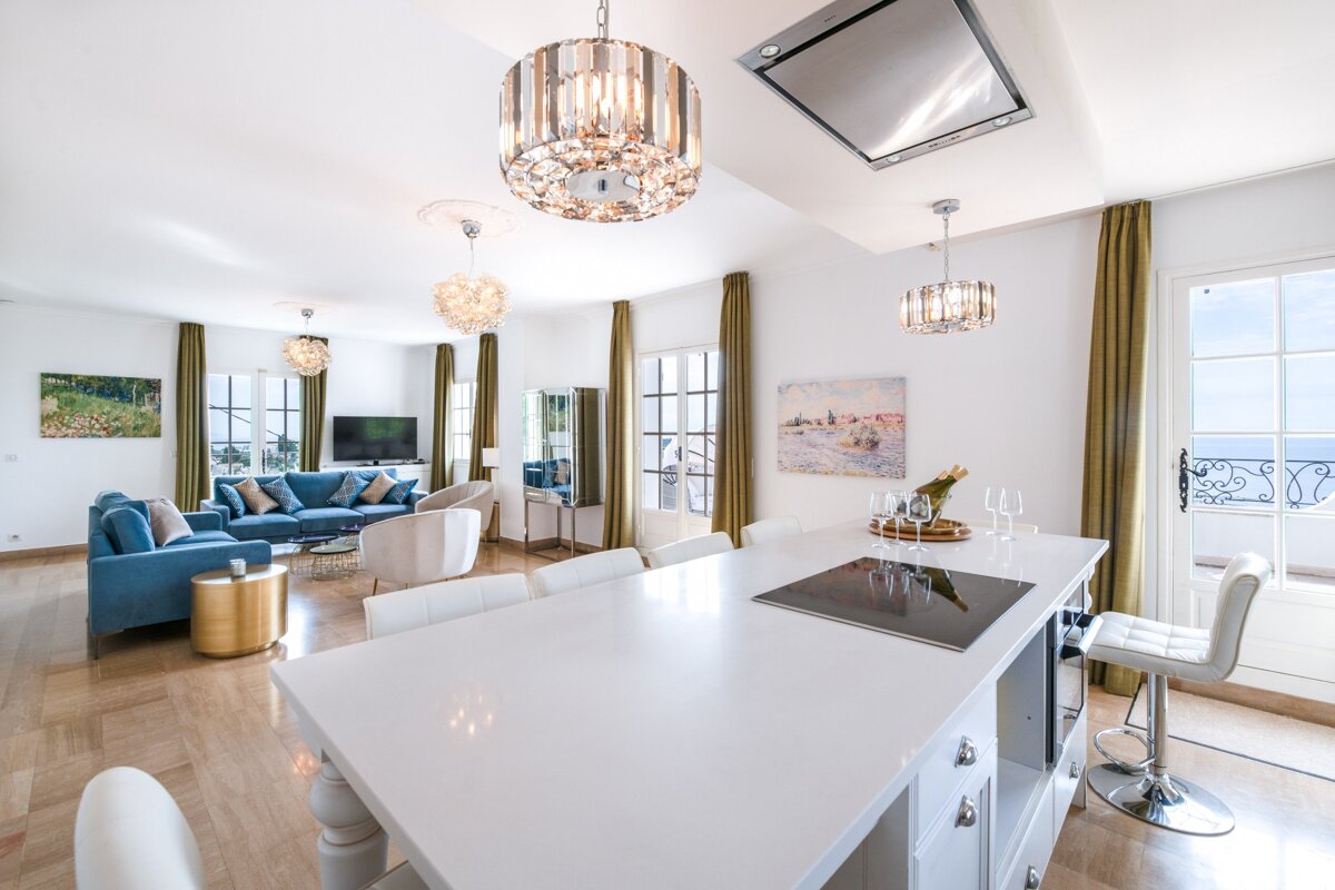 A living room with a blue couch and white chairs