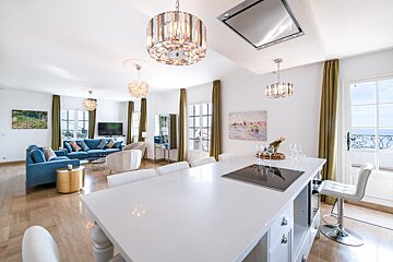 A living room with a blue couch and white chairs