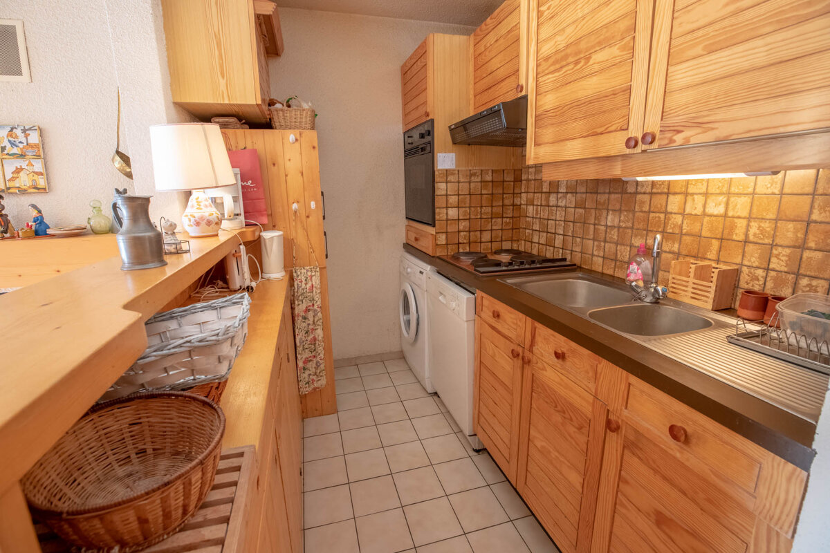 A small kitchen with wooden cabinets and a sink