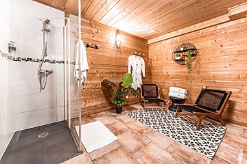 A bathroom with a walk in shower and chairs