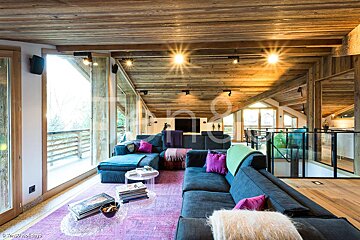 A living room with a blue couch and a purple rug