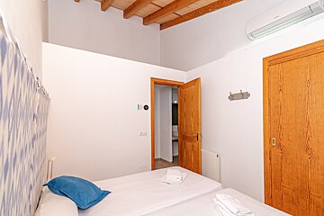 A bedroom with two beds and a door leading to a bathroom