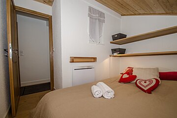 A bedroom with a heart shaped pillow on the bed