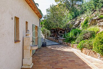 A brick walkway with a stone fountain and a sign that says home sud