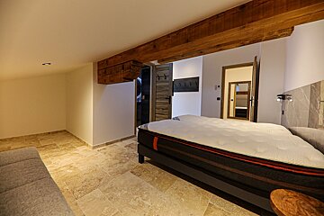 A bedroom with a mattress and a couch