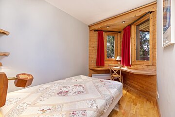 A bunk bed in a small room with a red curtain