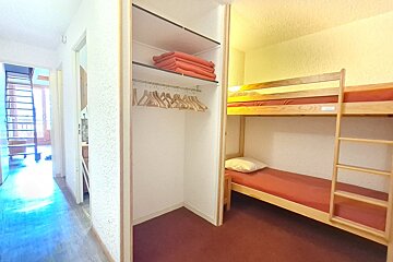 A bunk bed in a closet with a ladder