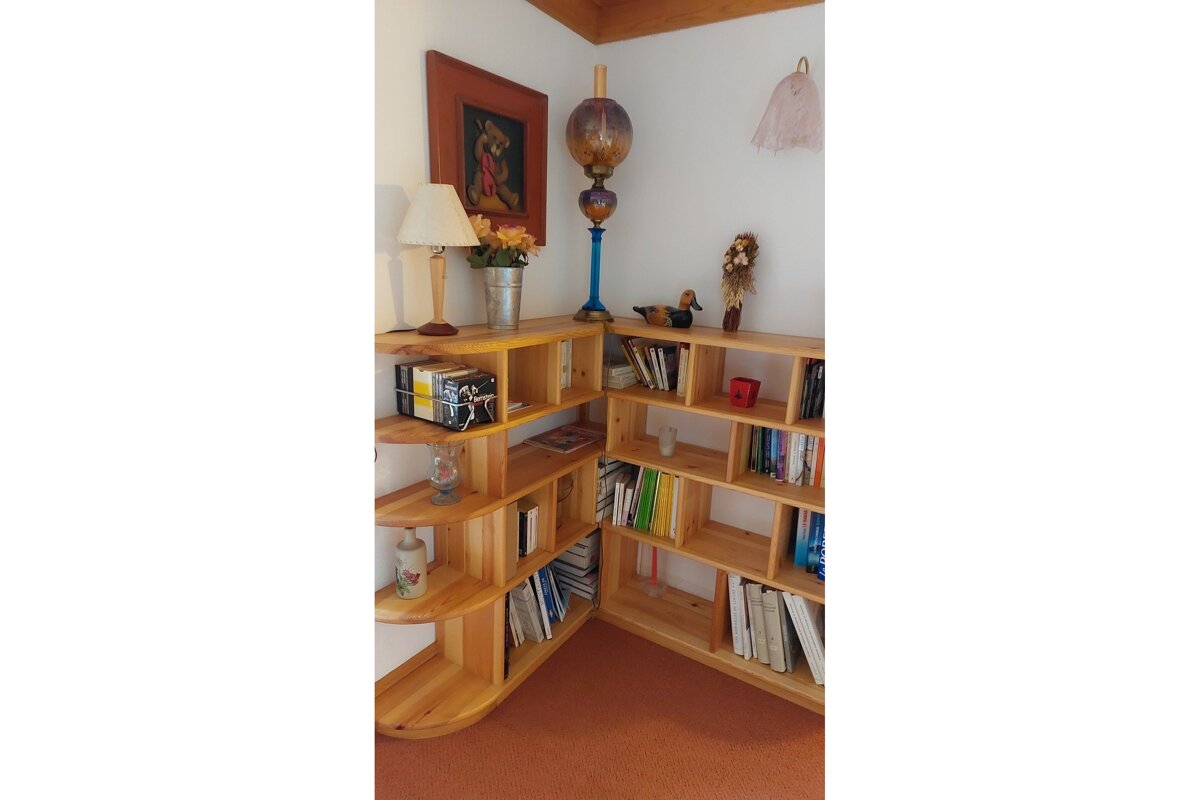 A corner of a room with bookshelves and a lamp