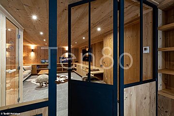 A room with wooden walls and a glass door that says ten80 on it