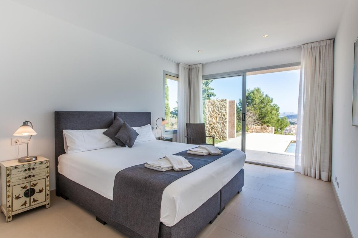 A bedroom with a large bed and a sliding glass door
