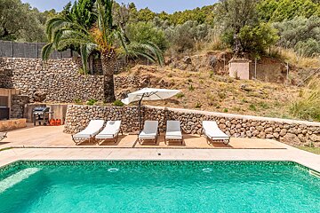 A swimming pool surrounded by chairs and an umbrella