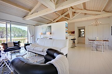 A living room with a white couch and black chairs
