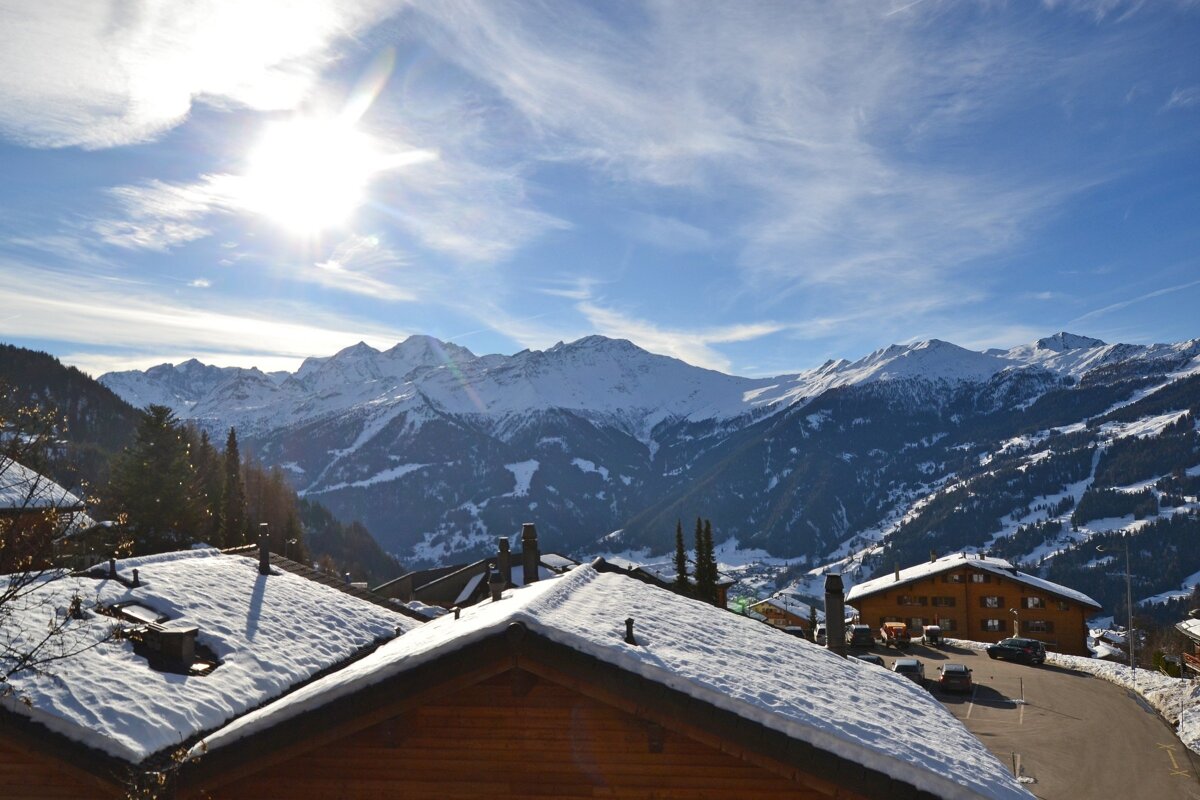 The sun is shining brightly over the snowy mountains