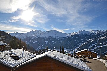 The sun is shining brightly over the snowy mountains