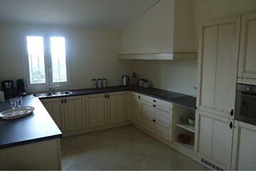 A kitchen with white cabinets and black counter tops