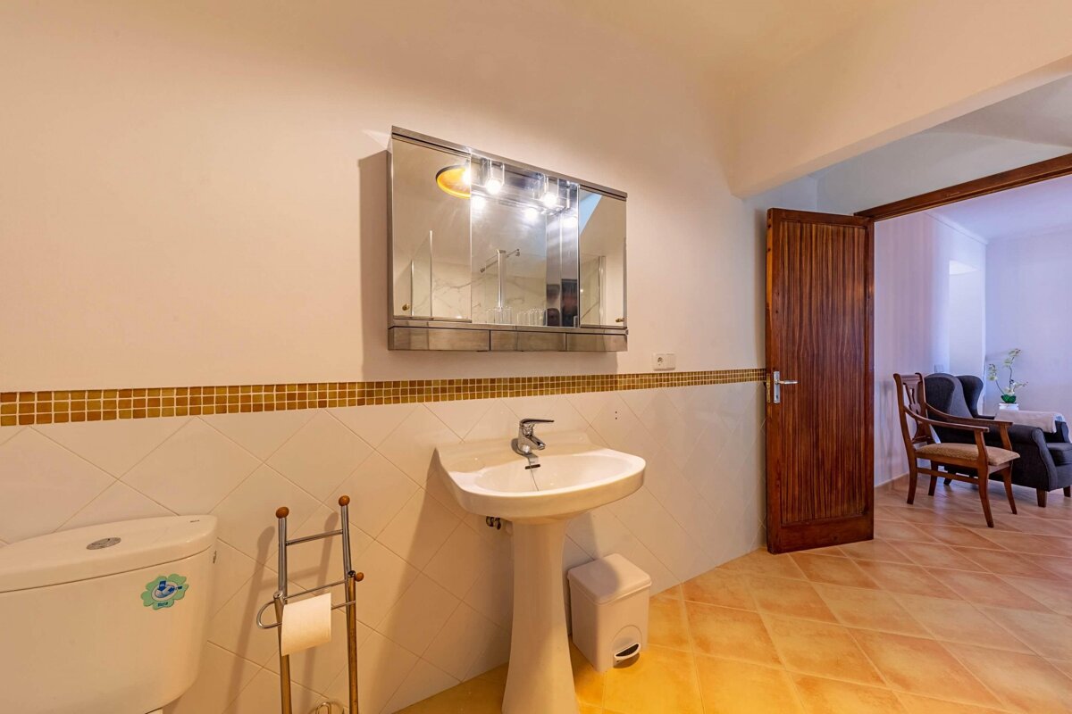 A bathroom with a toilet a sink and a mirror