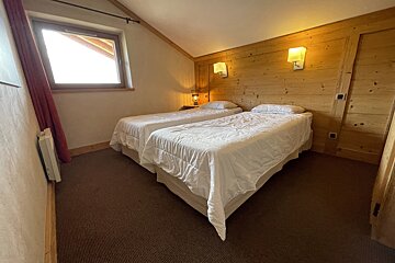 A bedroom with two twin beds and a window