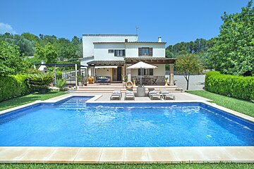 A house with a large swimming pool in front of it