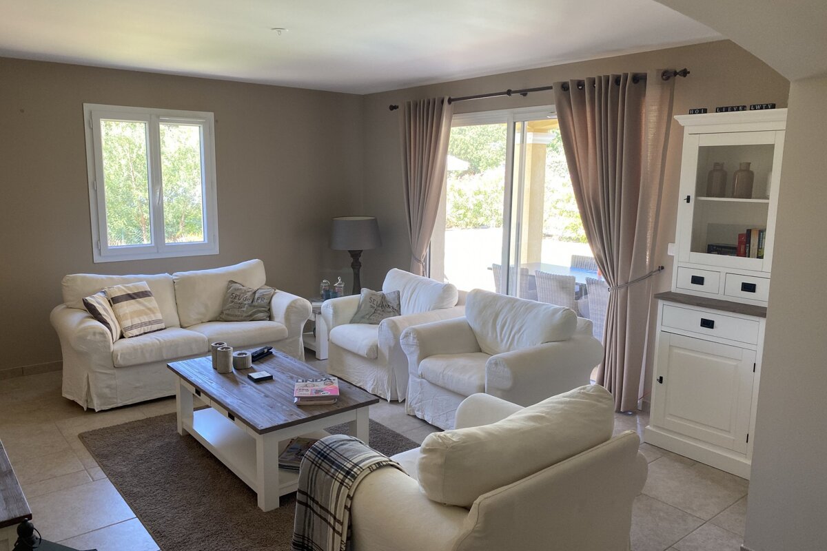 A living room with two white couches and a coffee table