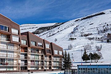 A building with balconies and a snowy mountain in the background