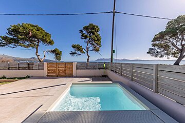 A small swimming pool is surrounded by a wooden fence