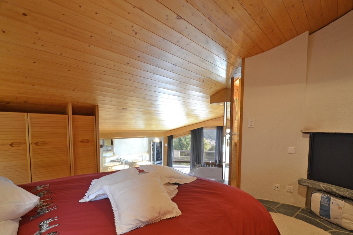 A bedroom with a round bed and a fireplace