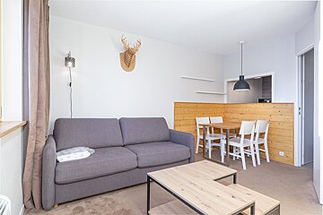 A living room with a couch a table and chairs