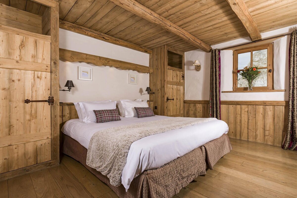 A wooden bedroom with a bed and a window