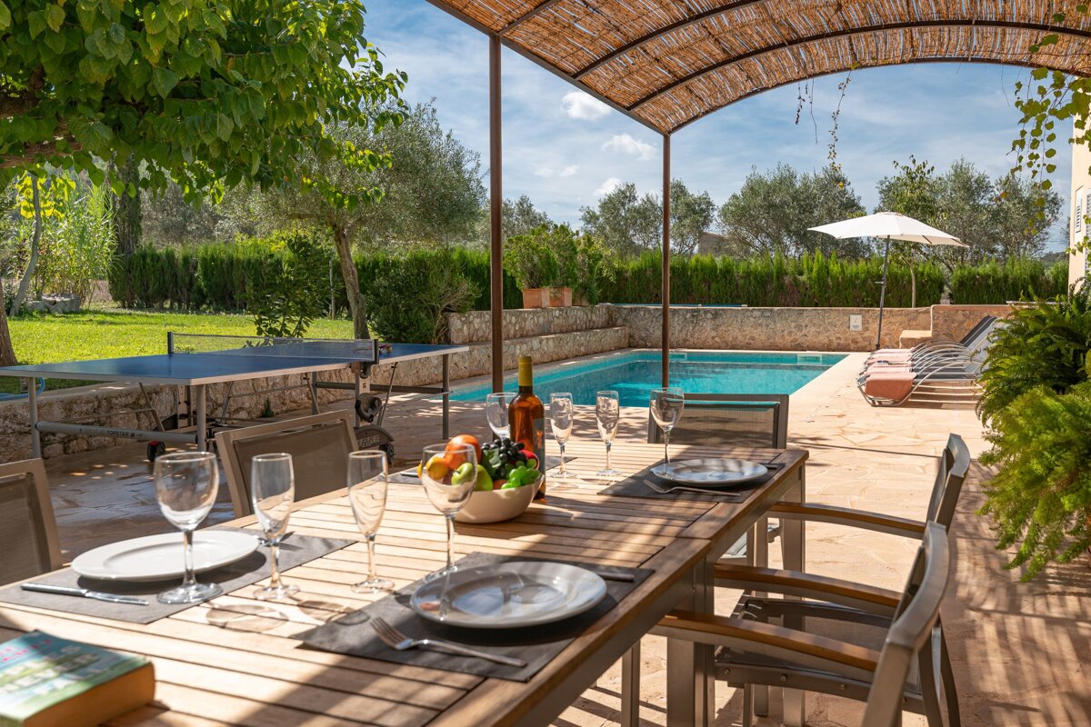 A table with plates and glasses and a bottle of wine