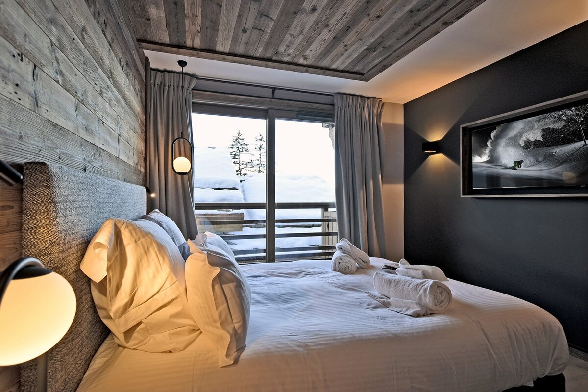 A bedroom with a large bed and a picture on the wall