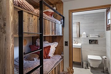 A bathroom with a bunk bed and a toilet