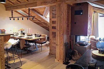 A dining room with a table and chairs and a fireplace