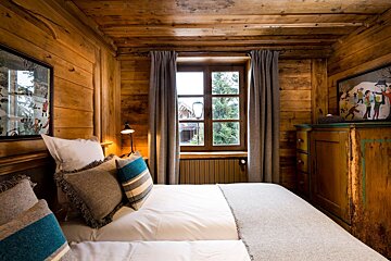 A bedroom with a bed and two pictures on the wall