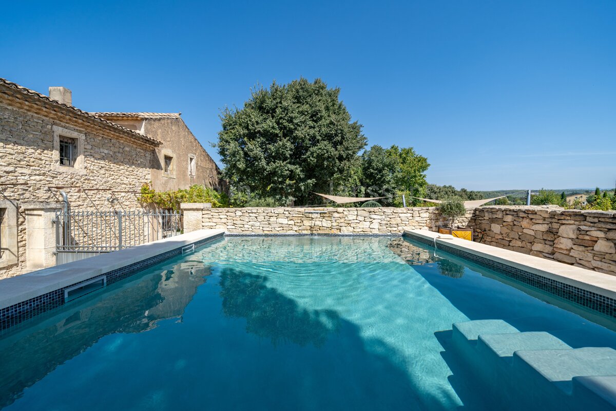 A large swimming pool in front of a stone building
