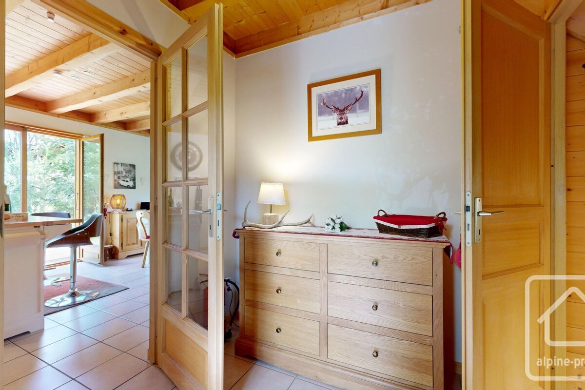 A picture of a deer hangs above a wooden dresser